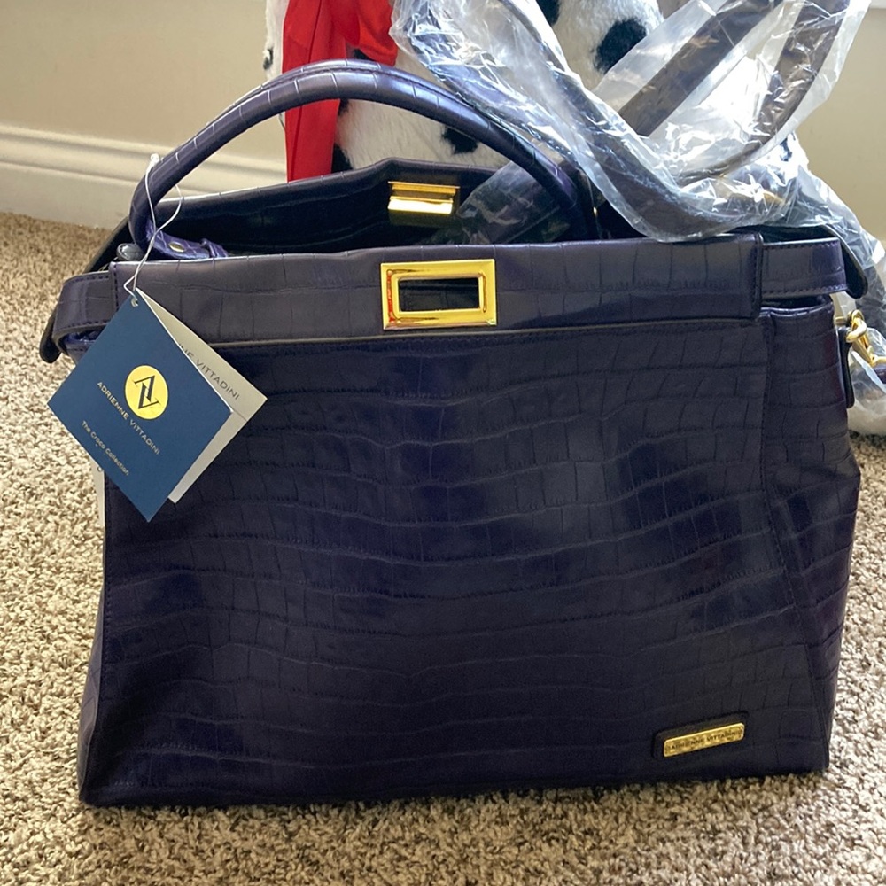 Never worn, purple faux leather, alligator print, with detachable strap.